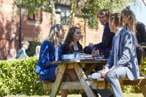 Students sitting on a bench outside St John's Sixth Form house